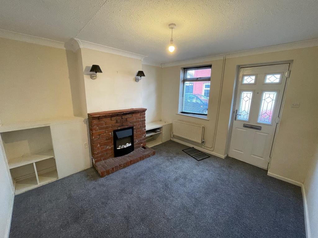Lot: 107 - TWO-BEDROOM TERRACE HOUSE - Living room with fireplance front door and window to front